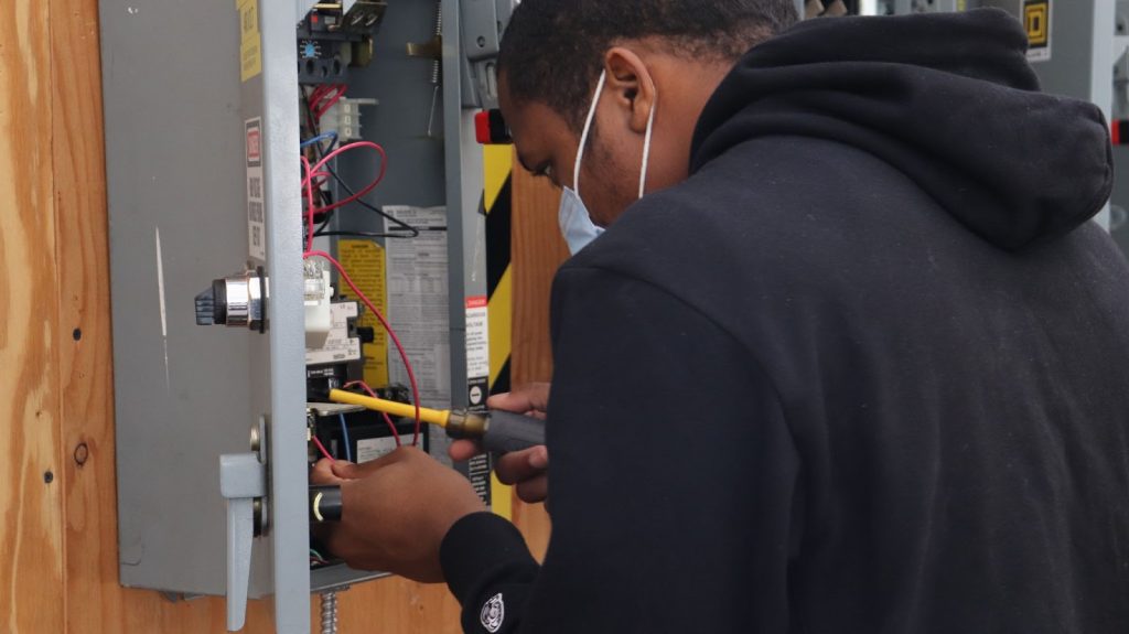 Instructor guiding student during automation and manufacturing equipment training