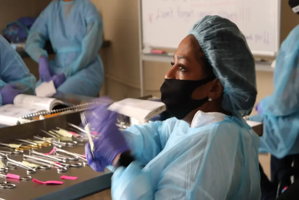 Sterile processing student hospital-grade sterilizer during CRCST training