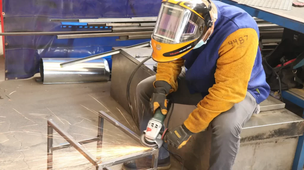 Student in a hands-on welding school in Philadelphia practicing at a welding booth