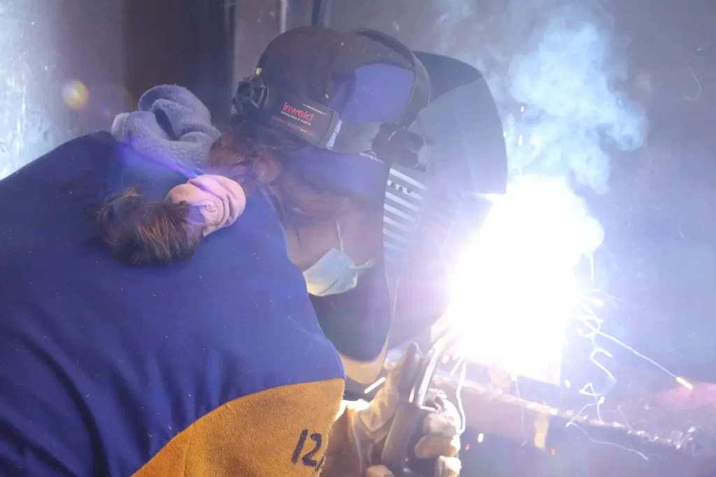 a welder welding together large industrial steel beams