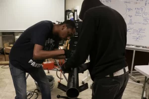 Instructor teaching pipefitting layout to students at a Philadelphia trade school