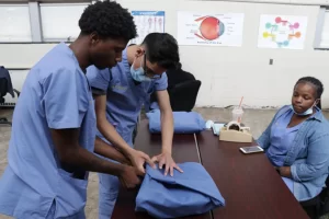 students at a PTTI sink station, all wearing proper PPE.