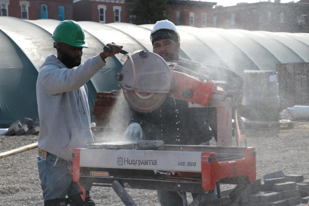 Students practicing masonry and concrete skills in a Philadelphia trade school construction site.