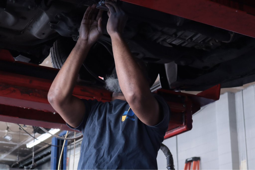 Two Philadelphia technical institute students fixing the car brake system issues.