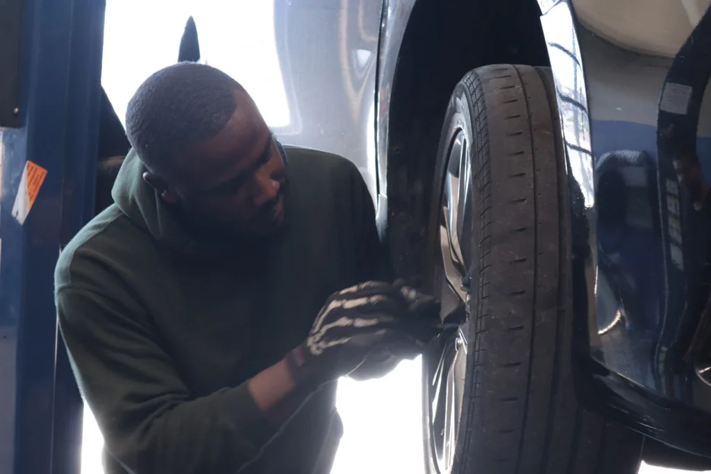 PTTI automotive student working on a vehicle lift during hands-on technician training in Philadelphia