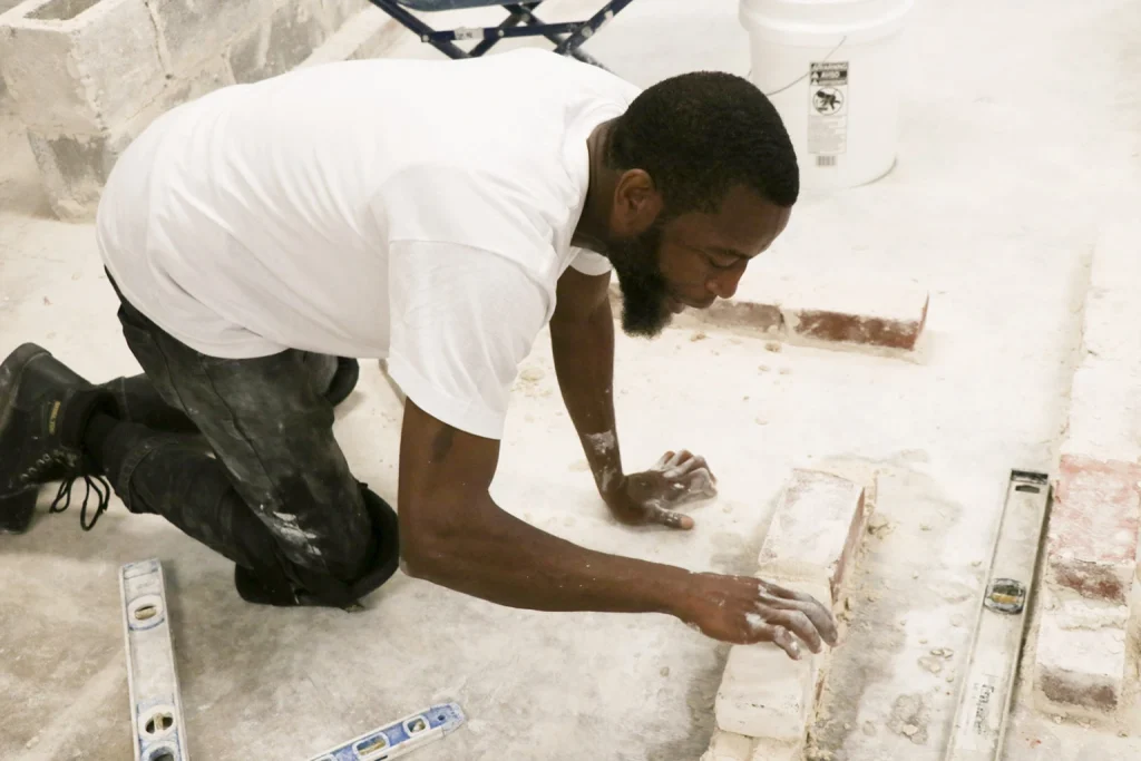 Student laying concrete blocks in a concrete masonry and framing class