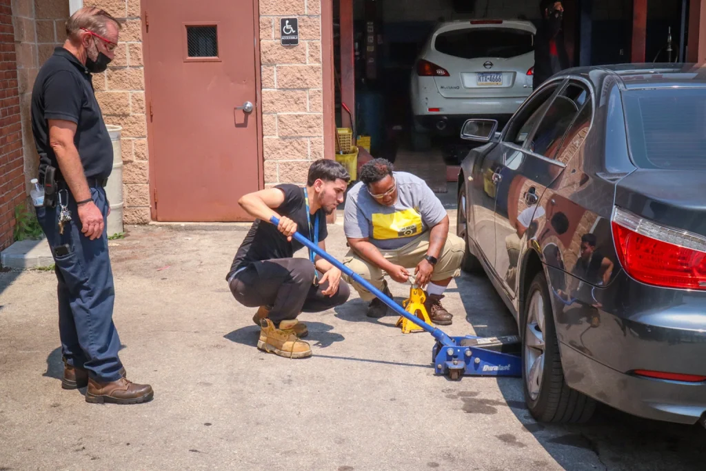 Two industrial workers checking a mechanical car