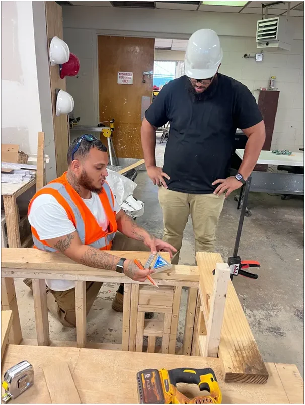 An Apprentice learning under experienced trades mentors 