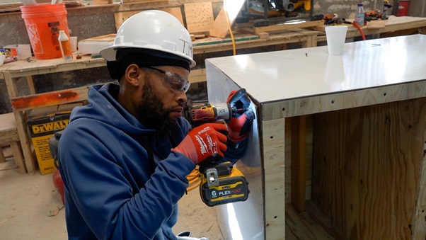 Worker using a power drill during concrete framing training
