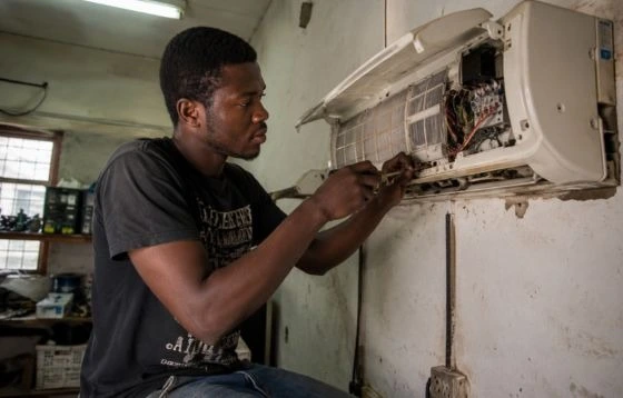 Future HVAC technician checking electrical components inside an HVAC unit