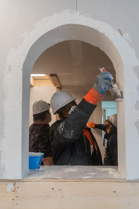 Drywall finishing and framing professional working at a construction job site