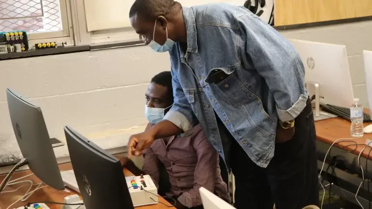 Students practicing on industrial control and automation trainers 
